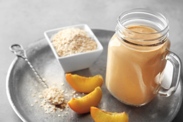 Mason jar with tasty smoothie and some ingredients on kitchen table