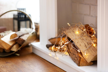 Logs and lights in decorative Christmas fireplace, closeup