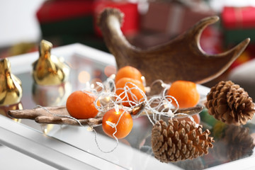 Mandarins and cones on table in decorated room