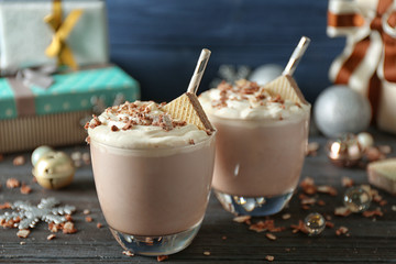 Delicious milkshakes with Christmas decoration on wooden table closeup