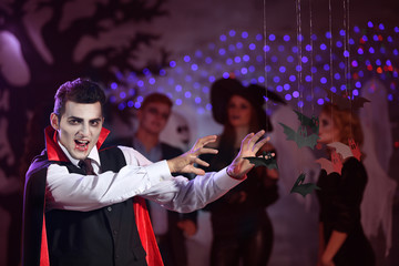 Young man in vampire costume at Halloween party