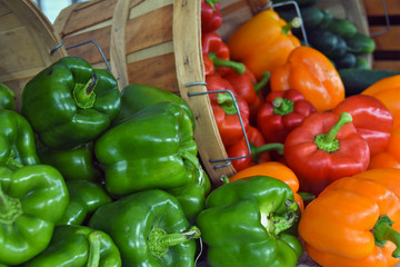 variety of peppers tumbling out of bushel baskets at the market