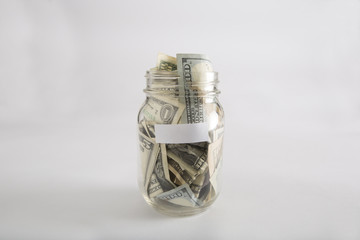 Closeup of Mason jar with money with blank label