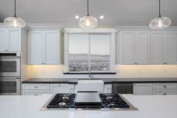 Amazing new contemporary with large white Kitchen with kitchen Island and grey counter tops.