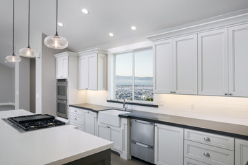 Amazing new contemporary with large white Kitchen with kitchen Island and grey counter tops.