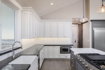 Amazing new contemporary with large white Kitchen with kitchen Island and grey counter tops.