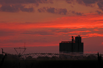 Fototapeta premium Sunset with Grain Elevator and Irrigation Pivot