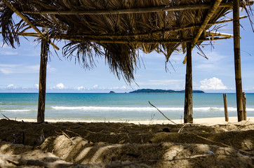 beautiful seaview through bamboo hut. palm fronds, sandy beach a
