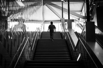 Silhouette of a young man climbing stairs inside interesting architecture