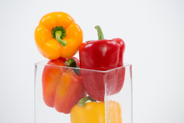Mixed bell peppers in glass vase tight group