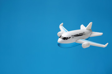 Fototapeta premium plastic toy plane flying on blue background