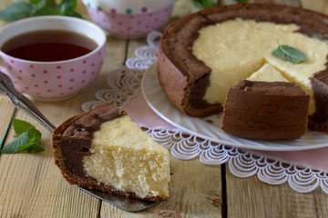 Pastry with cheese and chocolate cheesecake on a wooden table.