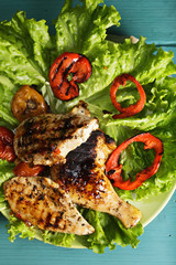 Grilled chicken breasts and leg on lettuce above view