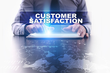 Fototapeta na wymiar Businessman is using tablet pc, pressing on virtual screen and selecting customer satisfaction.