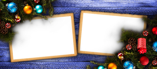 Merry Christmas Frame with real wood green pine, colorful baubles, gift boxe and other seasonal stuff over an old wooden aged background