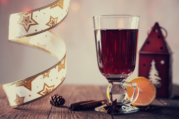 Hot mulled wine with spices, ribbon and house shaped candlestick 