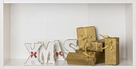 Wooden white XMAS letters on a white background with Packed gift