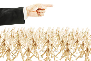 Many people going in shown direction. Concept of full obedience. Abstract image with a wooden puppet
