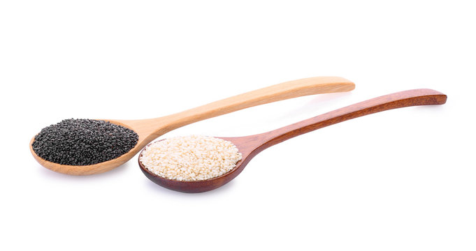 white and black sesame seeds in wooden spoon isolated on a white