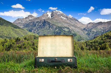 valigia vintage aperta con paesaggio alpino