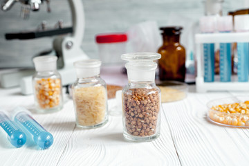 cereals in glass vials for analysis on wooden background