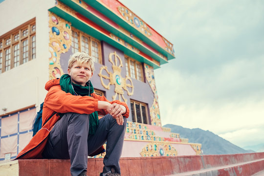 Traveler sits on the stairs of buddhist monastery in Small Tibet