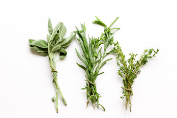 sage, rosemary, thyme - tufts of herbs white background