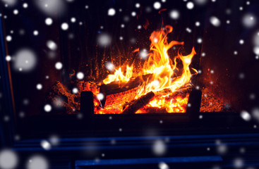 close up of firewood burning in fireplace and snow