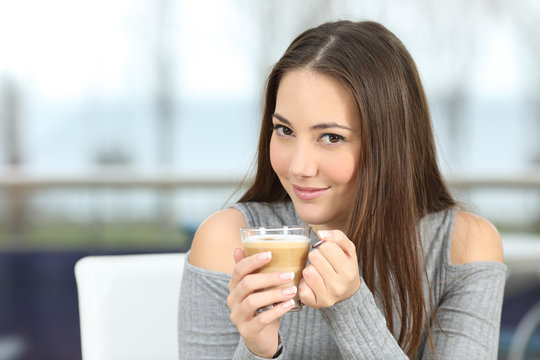 Confident woman posing holding a coffee cup
