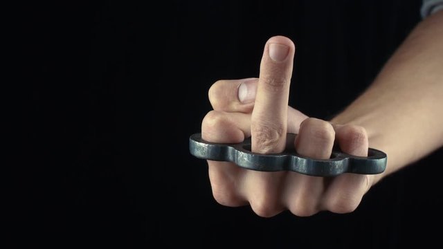 Male hand with knuckle-duster showing middle finger Fuck You