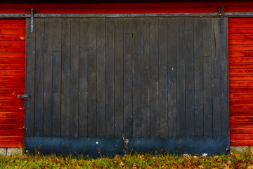 Wooden black sliding door on red barn.