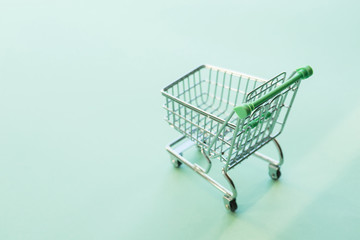 Empty shopping cart over the green background