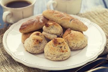 almond cookies on white plate and coffee on woden background