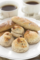 almond cookies on white plate and coffee on woden background