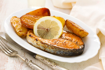 fried salmon on white plate on wooden background