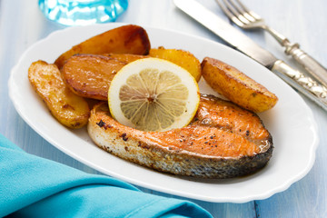 fried salmon on white plate on wooden background