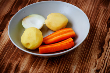 Poseshenie vegetables to prepare vegetable soup with spices on a light plate .
