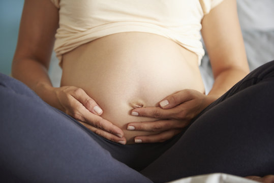 Pregnant woman strokes her abdomen