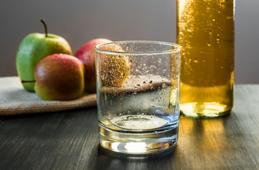 Empty glass, apples, apple wine ready to drink