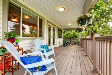 Large covered porch with railings and outdoor seats