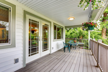 Large covered porch with railings and outdoor seats