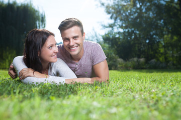 couple lying at grass in park in summer