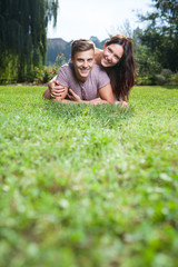 couple lying at grass in park with copy space