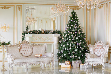 Christmas morning. classic apartments with a white fireplace, decorated tree, bright sofa, large windows