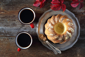 Homemade Kouglof, two cups of coffee and autumn leaves