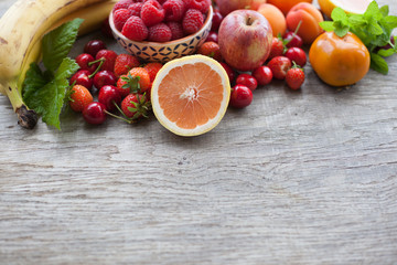Summer fruits and berries on a dark wooden table, with space for text, selective focus