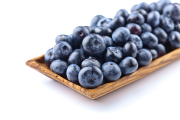 blueberries in wooden dish isolated on white