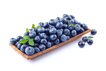 blueberries in wooden dish isolated on white