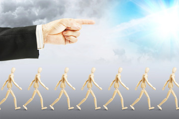 People walking to happy future. Concept of full subordination. Abstract image with a wooden puppet