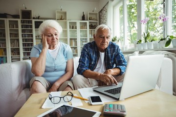Fototapeta premium Worried senior couple using laptop